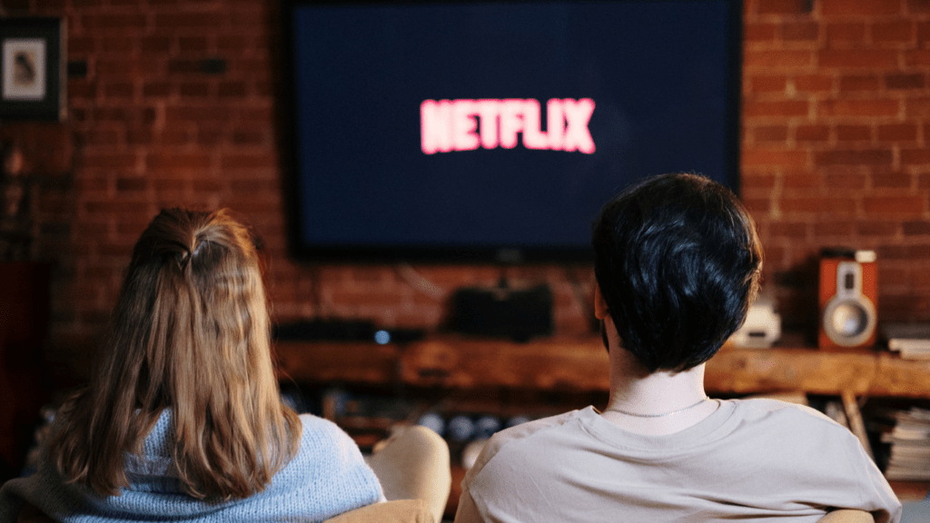 Couple installé sur un canapé qui regarde netflix
