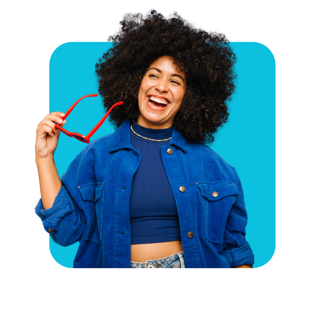 Femme noire afro qui sourit, tient des lunettes rouges habillée en bleu sur fond bleu - gestion des émotions